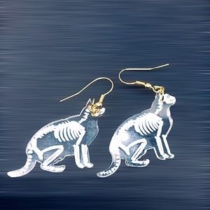 Acrylic cat skeleton x ray earrings.